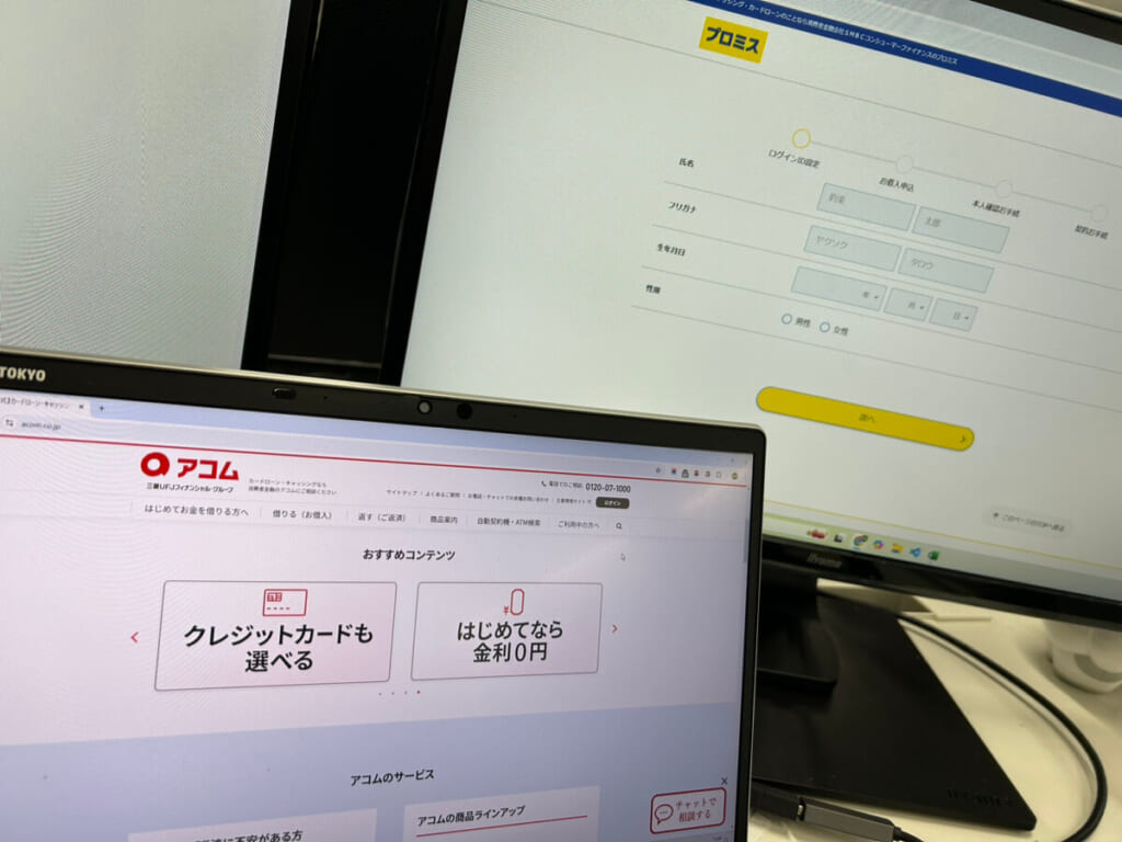 消費者金融のサイトを映している2台のモニター